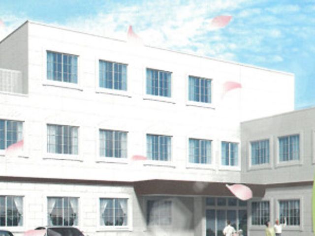 青空背景の白い建物正面 外観 ゆったりとした明るい外観の建物です。入口は広く、バリアフリー設計になっており、安心してご利用いただけます。