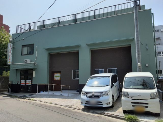 緑の外壁の建物 外観 緑色の外観が特徴的な建物です。車いすでも使いやすいエントランスとなっています。