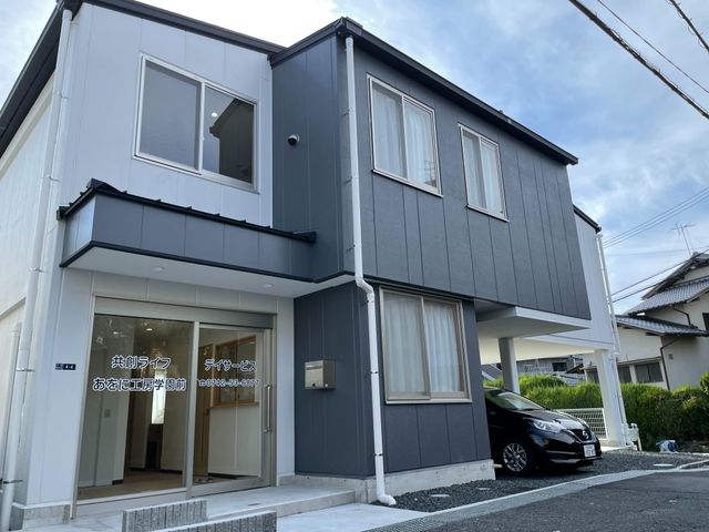 デイサービスの建物外観 外観   落ち着いた配色の建物で、1階の出入口はガラス扉になっています。駐車スペースも見えて、送迎時の動線を確認しやすいです。