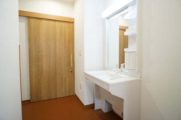 洗面台と木製扉の居室