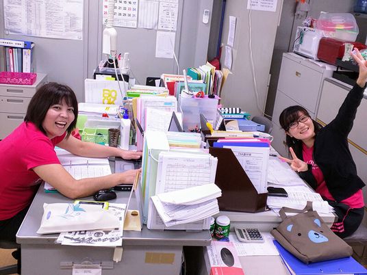 働くスタッフの笑顔の事務室