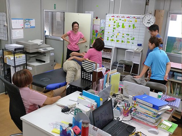 打ち合わせ中の事務所 スタッフイメージ 活気あるスタッフの会話が飛び交う事務所です。和やかな雰囲気が働きやすさを感じさせます。