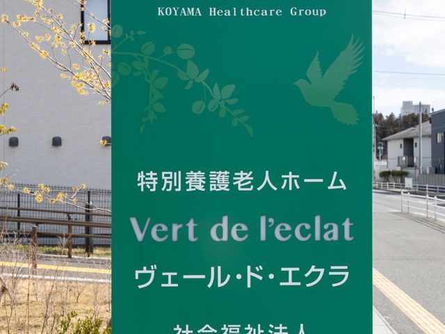 緑の看板 看板 爽やかな緑地に設置された看板が、施設の名称と運営法人を明確に示しています。