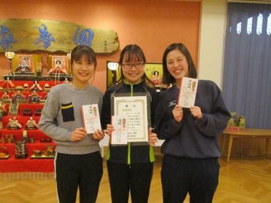 賞状を持つ3人が並ぶ室内  