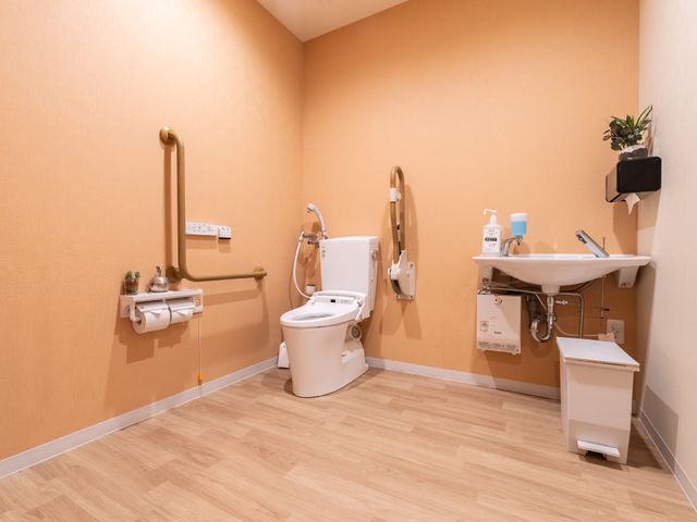 手すり付きトイレ空間 共有トイレ 手すりが設置された広々としたトイレです。利用者の安全と快適さを考えた配慮が感じられます。