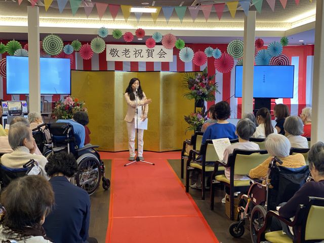 イベントが開かれている機能訓練室 機能訓練室 華やかな装飾の中、参加者が集まり交流を楽しんでいます。ログインや機能訓練も兼ねた空間です。