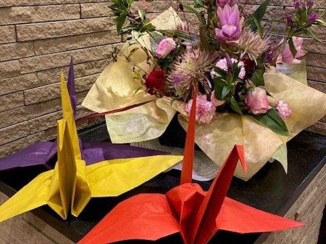 折り紙と花の飾り フロント 折り紙の鶴と華やかな花が飾られ、温かみのあるフロントの雰囲気が感じられます。
