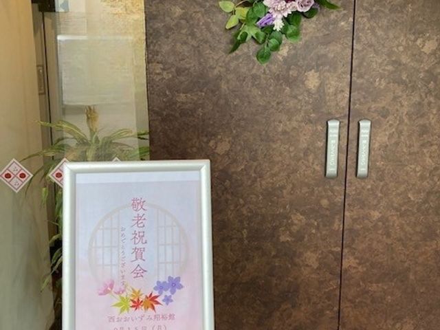 歓迎会の告知 エントランス エントランスには美しいフラワーアレンジメントが飾られ、心温まる雰囲気を演出しています。