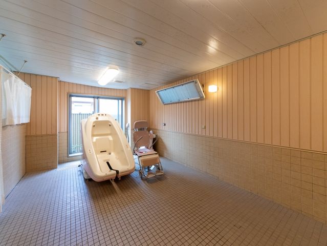 浴室の入浴機器と椅子がある浴室  