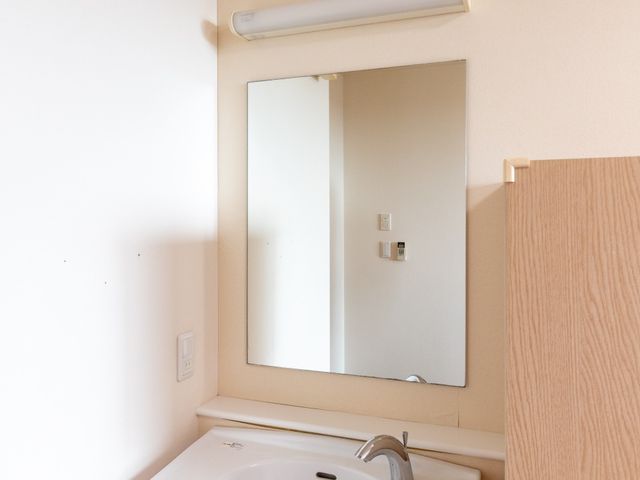 明るい洗面台のある洗面台 洗面台   白を基調とした明るい洗面台です。鏡と手元灯があり、身支度や洗顔がしやすそうです。