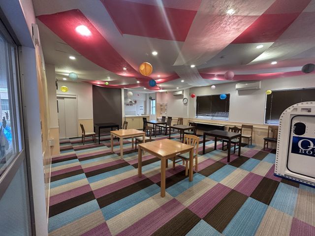 カラフルな空間の部屋 多目的室 カラフルな絨毯と天井が目を引く広々とした部屋です。様々な活動に対応できる多目的スペースです。