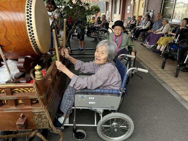 明るいエントランス外観 子供神輿④ ゆとりあるエントランスは、訪れる方々を温かく迎え入れます。周囲に緑を配し、開放感のある空間が広がっています。