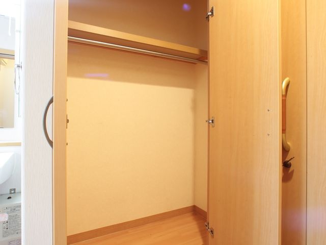 開いた木製のクローゼット 収納  ゆとりある収納スペースを備えた居室です。必要な物をすっきりと整理できる環境が整っています。