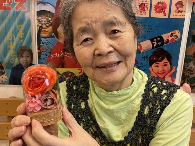 利用者の笑顔と作品 多目的室 作品を手にした利用者の穏やかな笑顔が印象的です。多目的な活動が楽しめる空間です。