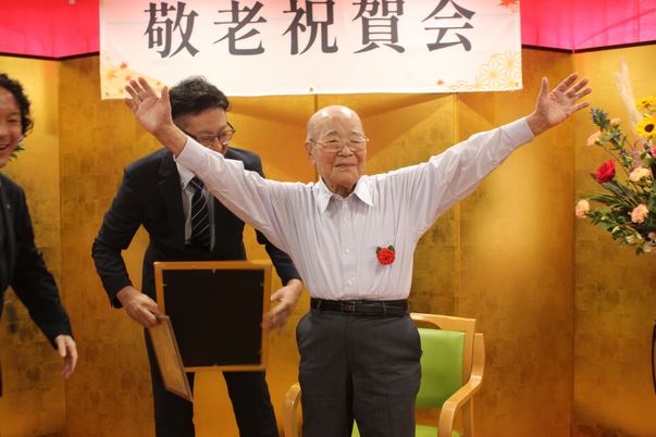 笑顔の高齢男性が中心の室内