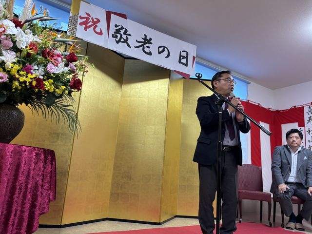 お祝いの場面 多目的室 華やかな装飾とともに催しが行われています。和やかな雰囲気の中でイベントが進行しています。