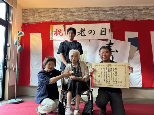 笑顔の高齢者とスタッフたち記念撮影