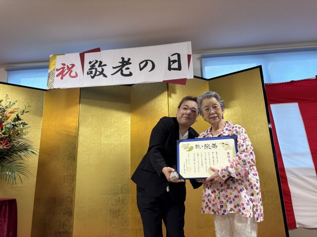 敬老の日の表彰の様子 内部 敬老の日の表彰式で、笑顔の方々が賞状を手にしています。温かい雰囲気が伝わります。