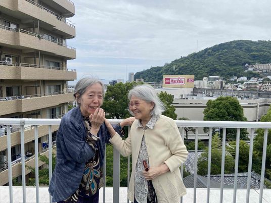 笑顔の女性ふたりがいる屋外スペース