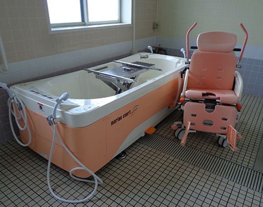 介護用バスタブと椅子の浴室  