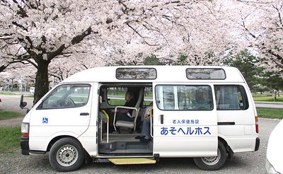 桜の下に停まる送迎車  