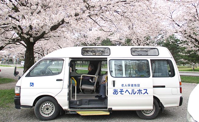 桜の下に停まる送迎車  