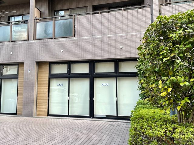 歩道沿いの建物外観 外観 開放的なガラス扉が印象的な建物は、周囲の緑と調和しています。