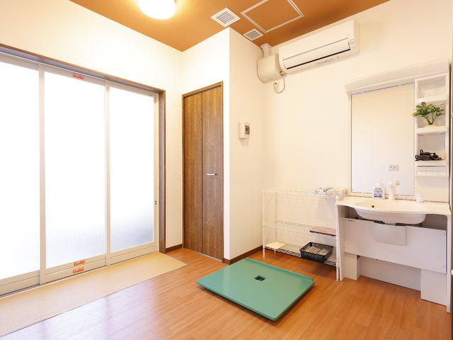 明るい和室の居室 脱衣所 清潔で広々とした居室には、大きな窓とシンプルな洗面台が備わり、心地良い日常生活を支えます。