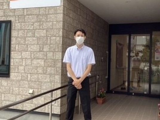 白衣の男性と施設エントランス