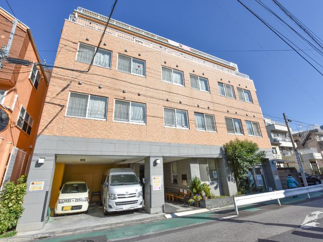 オレンジの建物の外観 外観 日当たり良好な明るい雰囲気の建物で、入り口には植栽があります。