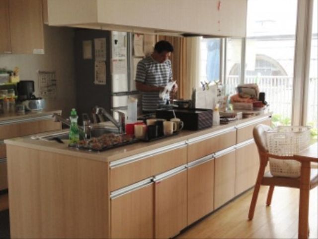 共有キッチンスペース キッチン 一人が作業中の温かみのあるキッチンスペースです。ゆったりとした環境で、料理のスキルを活かせる場所です。