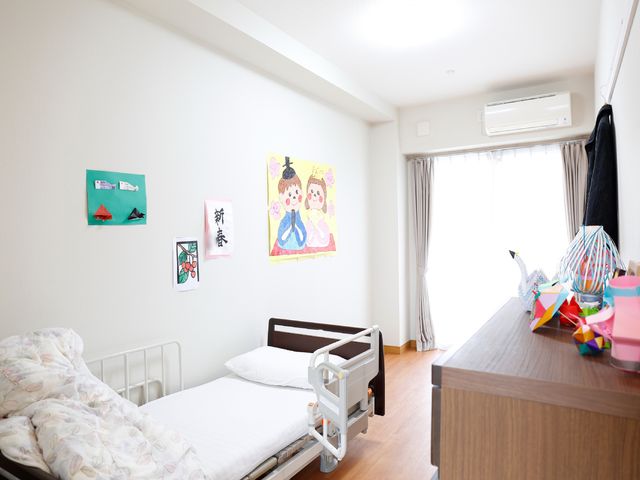 明るい居室の一角 居室 壁に飾られた絵や工芸品が、居室に温かみを与えています。