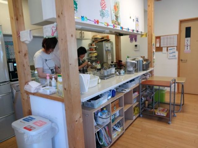 キッチンカウンターとスタッフ キッチン ゆとりあるキッチンでスタッフが調理中です。清潔感のあふれる環境で、お食事の準備が行われています。