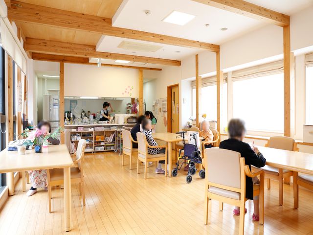 木のぬくもりある食堂空間 リビング 明るく開放的なダイニングで、利用者が食事を楽しむ様子が見えます。