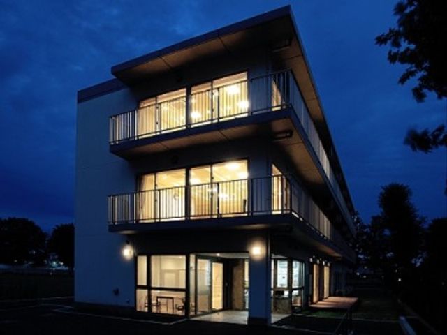 夜景の照らされた居室 外観 夜にも安らぎを感じられる居室です。暖かな灯りが窓からあふれ、落ち着いた時間を提供しています。