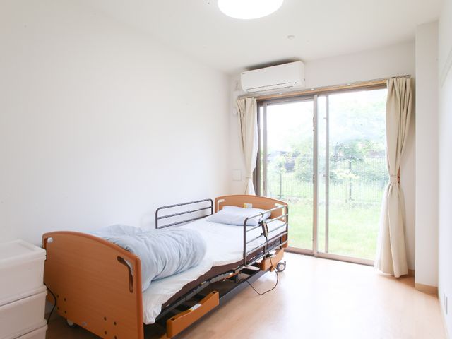 明るい居室の窓とベッド 居室 ゆったりとしたベッドと窓からの自然光が心地よい空間を演出しています。
