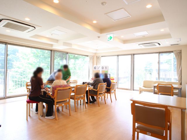 明るいダイニングルーム リビング ゆったりした空間で食事を楽しむ人々、窓から差し込む自然光が心地よいです。