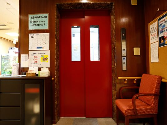 赤いエレベーターの扉と掲示物