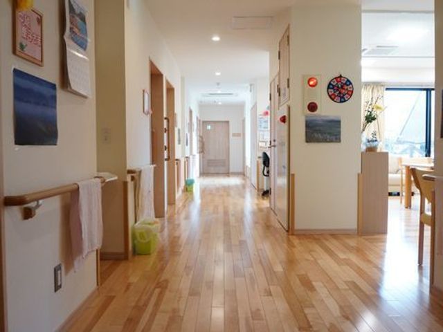 明るい廊下の風景 共有廊下 手すりが備えられた温かみのある廊下は、安心して歩ける設計となっております。窓から差し込む自然光が、穏やかな雰囲気を作り出しています。