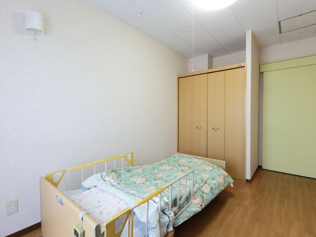 居室の広々とした空間 居室(別カット) ゆとりある居室で、プライベートな時間を大切にできます。きれいな床と落ち着いた色合いの家具が心地よい空間を作り出しています。