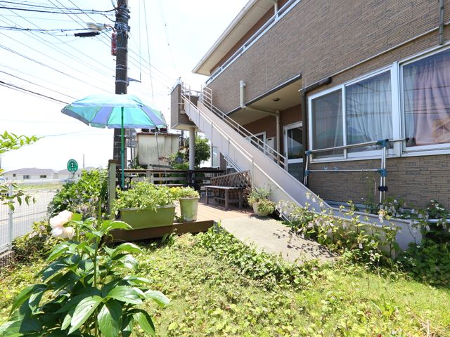 緑に囲まれた施設の外観 庭(避難経路) 施設周りには緑が多く、居心地の良い空間が広がっています。デッキで植物のお世話を楽しむことができそうです。