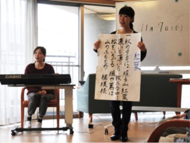 楽しい催しの様子 レクリエーション 笑顔で歌の発表をしているスタッフさんがいます。活気ある雰囲気のこの場所で、仕事のやりがいを感じることができそうです。