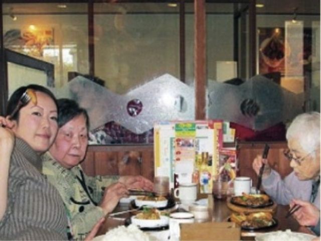 食事を楽しむ人々 食事 支え合いながら食事を取る暖かい雰囲気が感じられる食堂です。多様な料理を囲みながら、心地よい会話を楽しめる場所となっています。