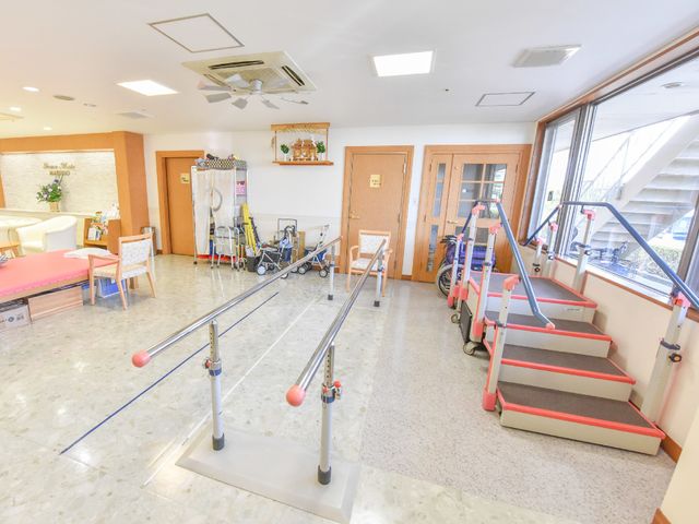 機能訓練設備のある空間 機能訓練室 広々とした明るい機能訓練室です。リハビリテーションのための階段や平行棒がしっかり整備されており、安心して身体機能の向上を図れます。