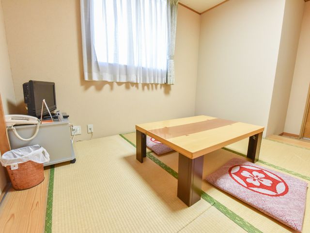 和室の居室 ゲストルーム ぬくもりを感じさせる畳の部屋です。テーブルと座布団が設えられ、くつろぎの時間を過ごせる空間となっています。