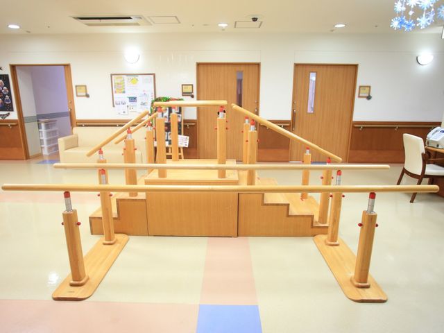 機能訓練用の階段と手すり 機能訓練室  明るく広々とした空間に設置された階段は、利用者の体力向上を助けます。手すりがあるため、安心して歩行訓練が行えます。