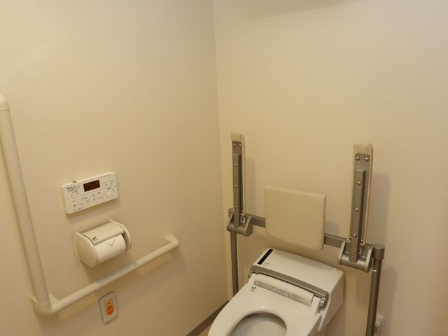 バリアフリー設計のトイレ 個室内トイレ 使いやすさを考慮したトイレです。手すりや緊急呼び出しボタンも設置してあり、安心してご利用いただけます。