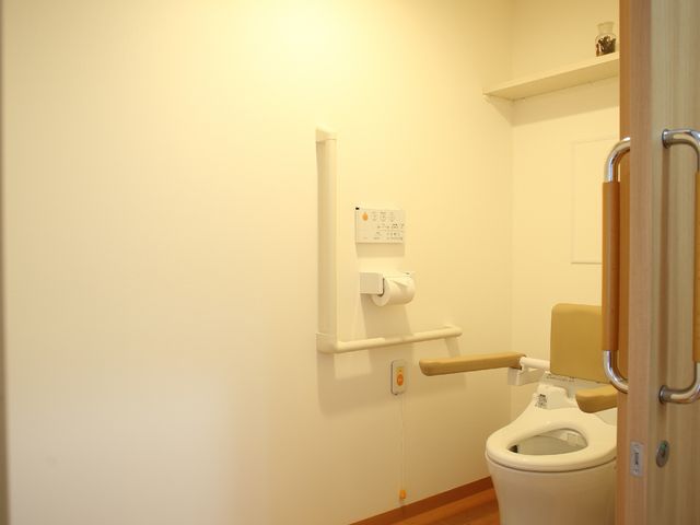 バリアフリー設計のトイレ トイレ 手すりが設置された広々としたトイレです。安全に配慮された環境で、利用者様の快適な生活をサポートしています。
