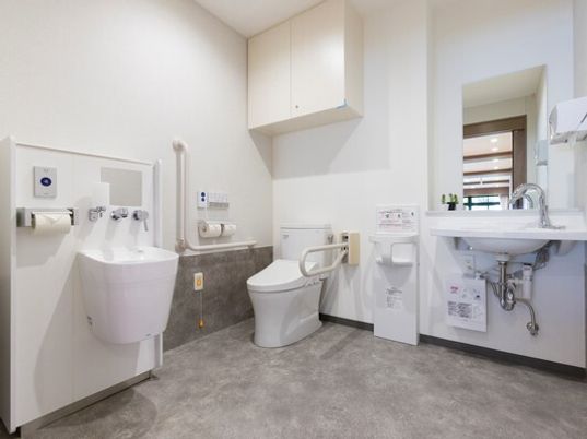 小さな子供用の椅子や手洗い場が設置された広いトイレはオストメイト対応。便座の上には収納スペースもある。