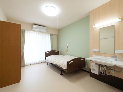 居室の洗面台とベッド
